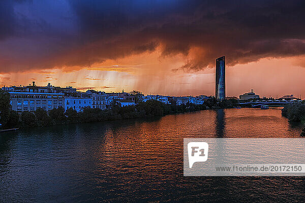 Spain  Andalusia  Seville  Guadalquivir river and surrounding buildings at stormy twilight