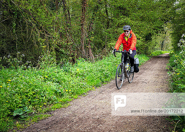 Senior man cycling along Cuckoo Trail in East Sussex  France
