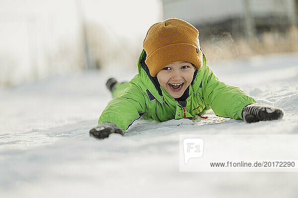 Cheerful boy lying on snow