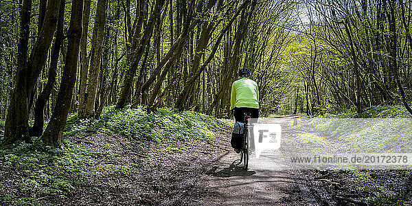 Senior man cycling on dirt road at Cuckoo Trail in East Sussex