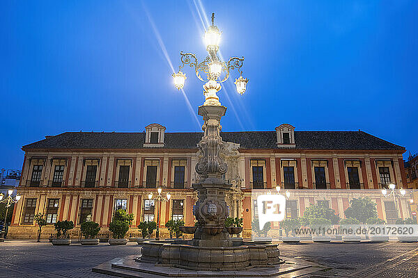 Spain  Andalusia  Seville  Archbishops Palace and Fuente Farola street light at dusk
