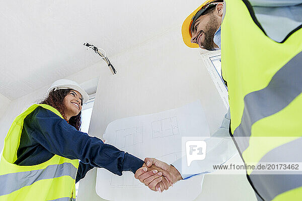 Young engineers doing handshake at construction site