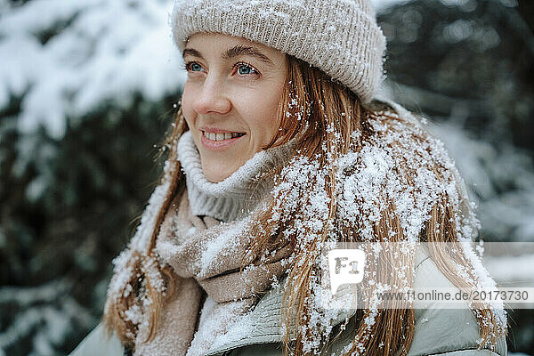 Smiling woman with snow on brown hair in winter