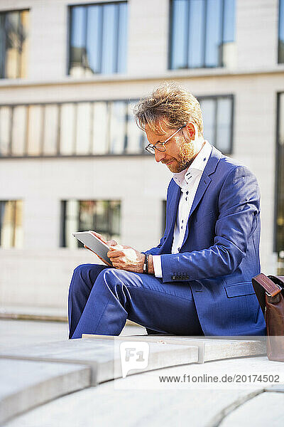 Businessman working on tablet PC in the city