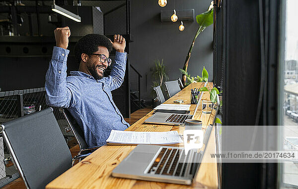 Successful businessman sitting with laptops at desk