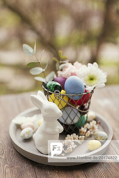 Easter decoration with eggs and flowers in basket on tray