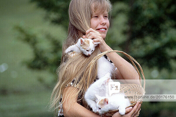 Children. Girl outdoors with pet kittens.
