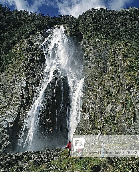New Zealand. South Island. Southland Province. Milford Sound. Bowen Falls with tourists.