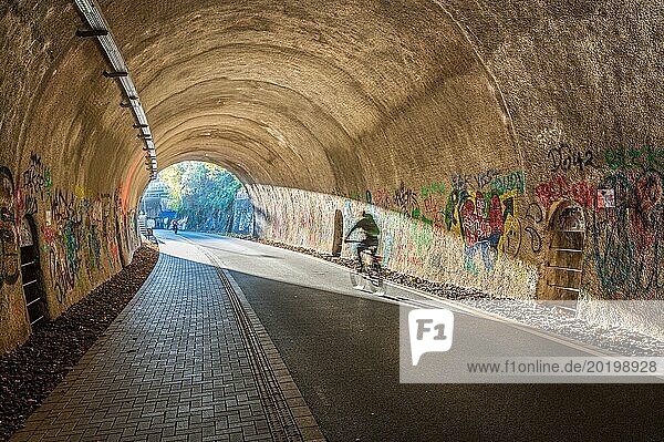 Eine Person auf einem Fahrrad fährt durch einen mit Graffiti verzierten Tunnel  Nordbahntrasse  Elberfeld  Wuppertal  Bergisches Land  Nordrhein-Westfalen