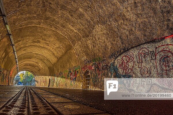 Radweg durch einen Tunnel mit buntem Graffiti an den Wänden und Gleisen auf dem Boden  Nordbahntrasse  Elberfeld  Wuppertal  Bergisches Land  Nordrhein-Westfalen