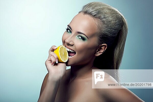 Schöne junge Frau lächeln und schmecken Zitrone