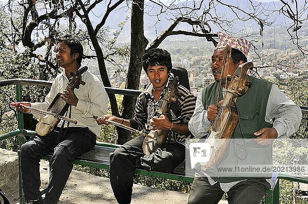 Drei Straßenmusiker spielen auf traditionellen Instrumenten und unterhalten Passanten  Kathmandu-Tal  Kathmandu  Nepal  Asien