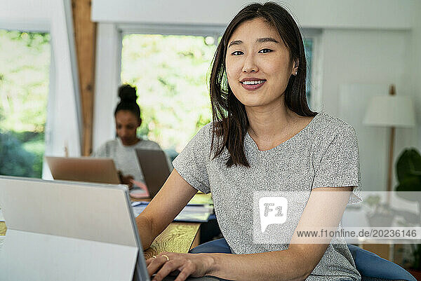 Female community manager using digital tablet while sitting at desk