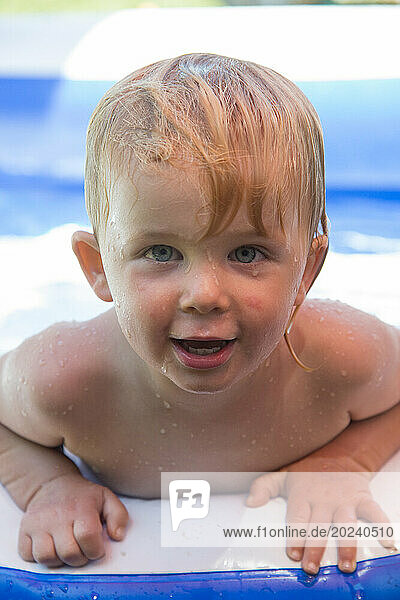 Toddler boy in a float toy in a pool; San Diego  California  United States of America