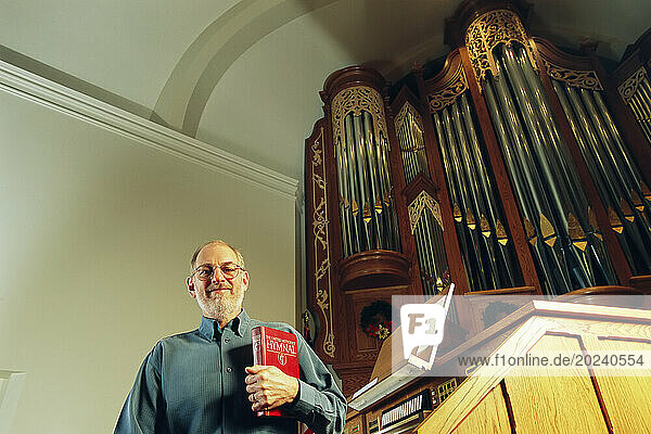 Organ manufacturer in a church with one of his company's organs; Lincoln  Nebraska  United States of America