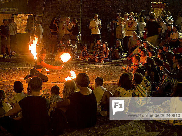Fire juggler entertaining people at night  medieval reenactment; Grottazzolina  Fermo province  Marche  Italy
