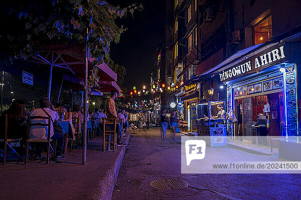 Customers enjoy a fish restaurant on a street at night in Karakoy  Istanbul; Istanbul  Turkey