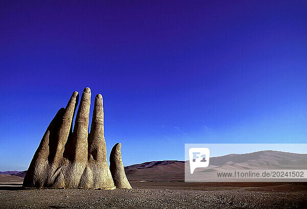 Giant hand sculpture (Mano De Desierto constructed by Chilean sculptor Mario Irarrázabal) rises from the desolate Atacama Desert  along the Pan American Highway; South of Antofagasta  Chile