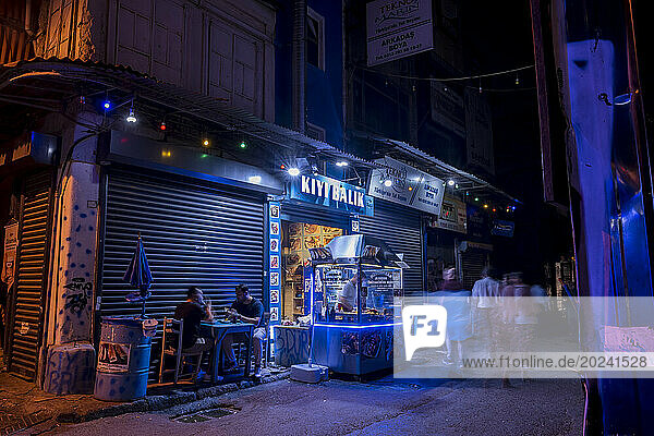 Customers enjoy a fish restaurant on a street at night in Karakoy  Istanbul; Istanbul  Turkey