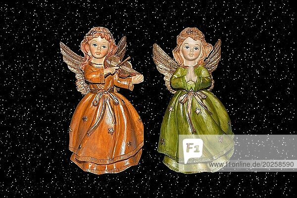 Zwei Engel  Weihnachtsengel  Figur  liest ein Buch  Weihnachten  Advent  Kirche  Religion  Hintergrund  Sterne  Sternenhimmel  Geige  Musikinstrument  Studio