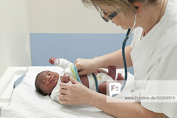 The pediatrician checks the newborn's heart rate.