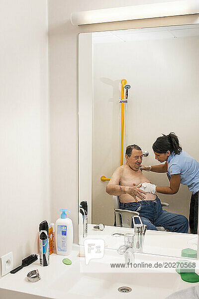 EHPAD - Hearing-impaired caregiver washing an elderly deaf resident.