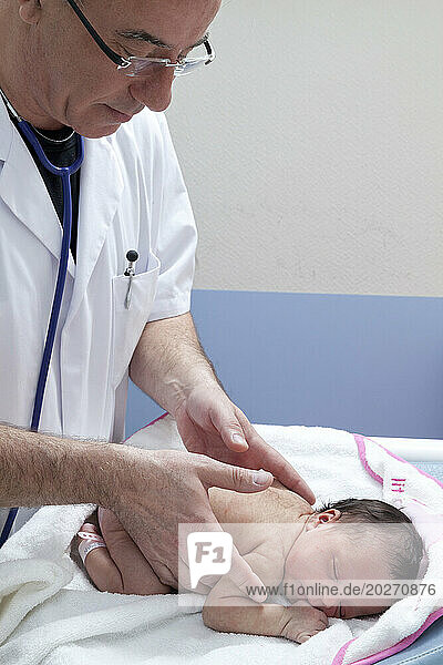 The pediatrician checks the vertebral column.