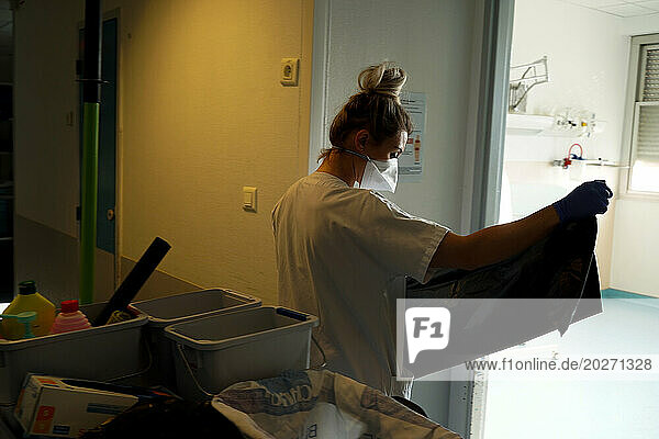 Nursing assistant cleaning a room in the emergency department of a university hospital.