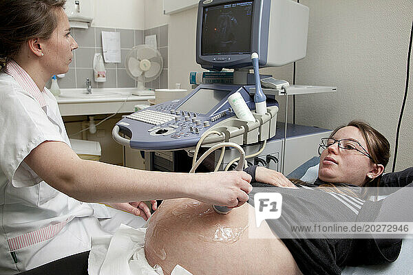 4th year student midwife performing a prenatal ultrasound under the supervision of a midwife. 391/2 weeks pregnant woman.