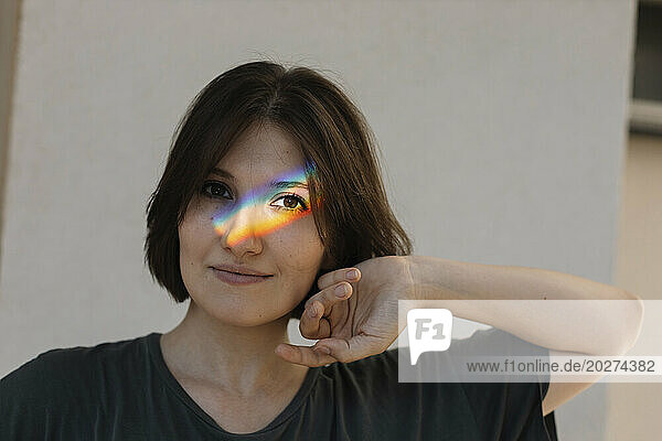 Rainbow colored light on woman's face