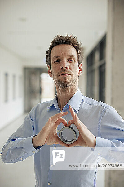 Engineer making heart shape with round object at workshop