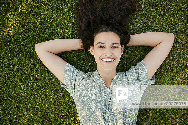 Smiling beautiful woman lying on grass