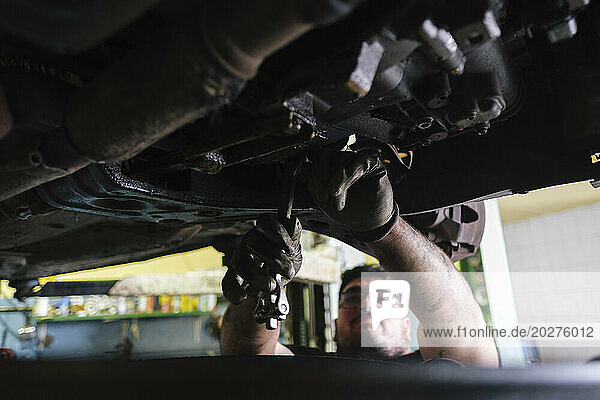 Mechanic disassembling vehicle parts at workshop
