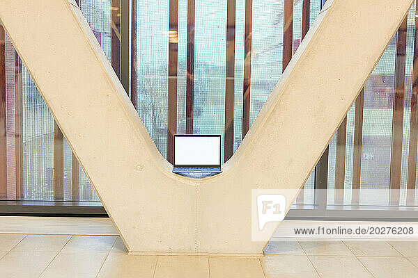 Laptop kept amidst architectural columns in office
