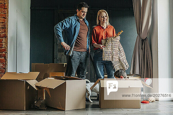 Happy family packing cardboard boxes for moving