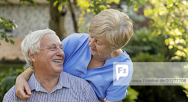 Happy senior man spending leisure time with woman in garden