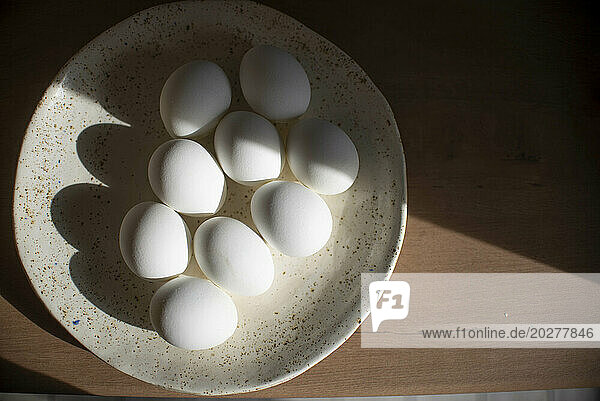White Easter eggs arranged in plate on table at home