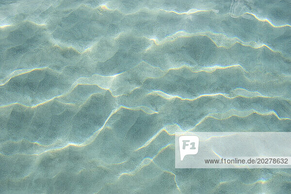USA  United States Virgin Islands  St. John  Patterns in sand beneath light reflecting on water surface