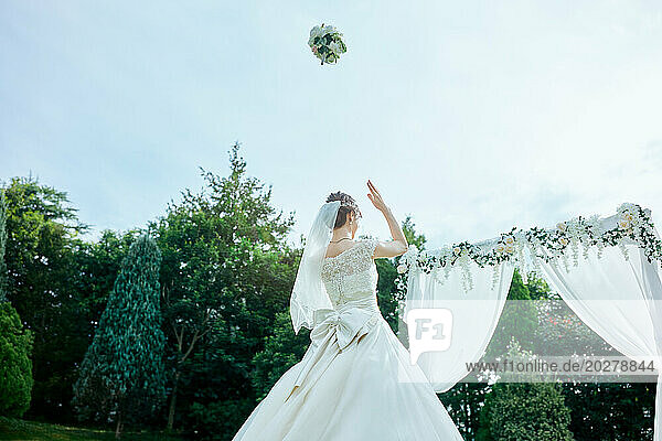 A bride tosses her bouquet into the air