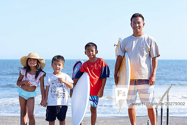 Family with surfboards at the beach