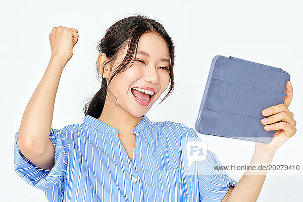 A woman holding up a tablet computer and smiling