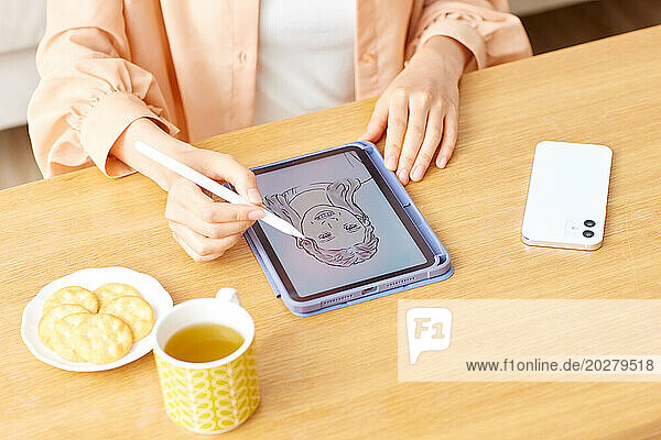 Eine Frau zeichnet mit einem Stift auf einem Tablet