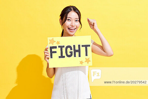 A woman holding up a sign that says fight