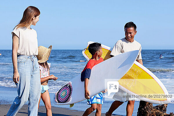 Family with surfboards at the beach