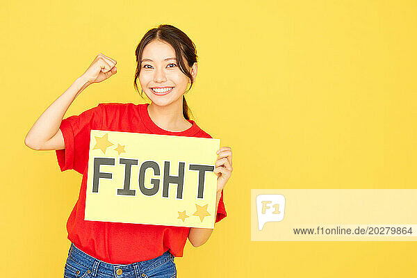 Woman holding up a sign with the word fight
