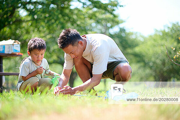 A man and a boy playing in the grass