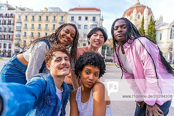 Fröhliche  heterogene junge Männer und Frauen machen ein Selfie in der Stadt