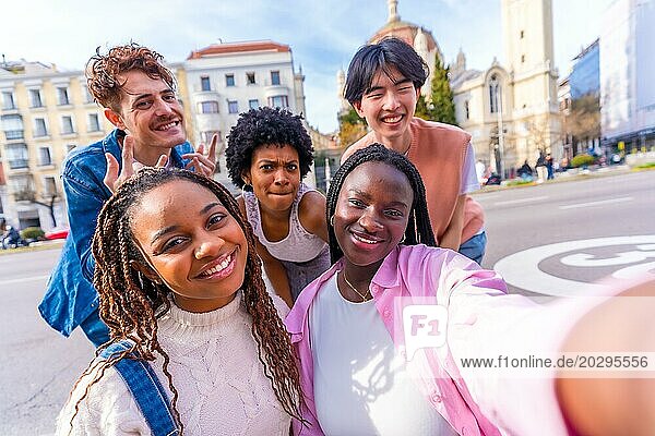 Glückliche junge multiethnische Freunde machen ein Selfie in der Stadt an einem sonnigen Tag