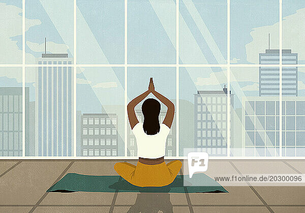 Woman practicing yoga meditation at window with cityscape view