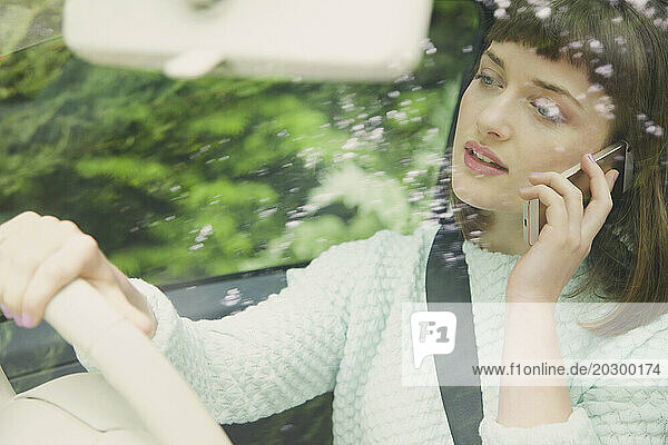 Close up of Teenage Girl Talking on Smartphone whilst Driving